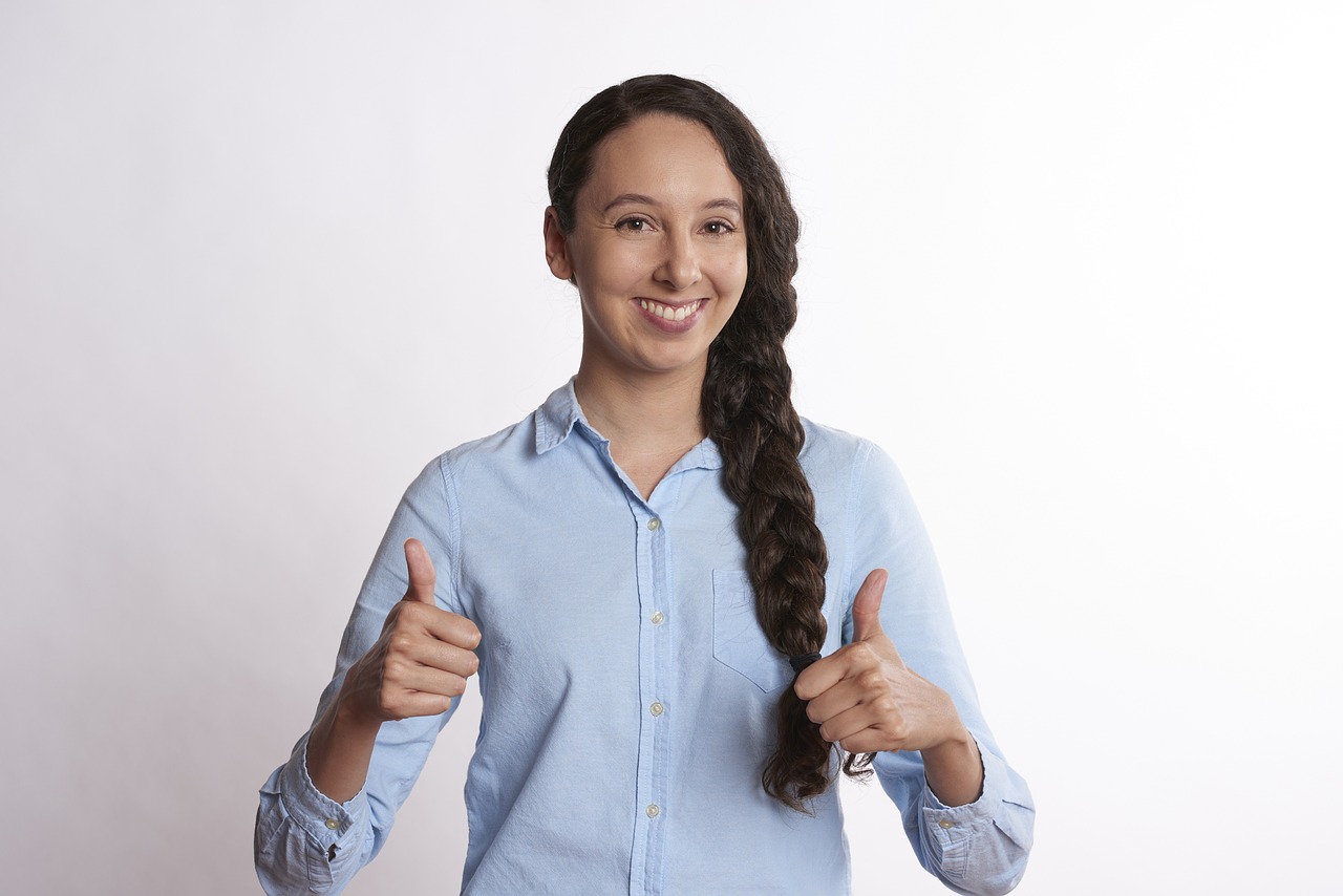 両手でグッドサインをする女性
